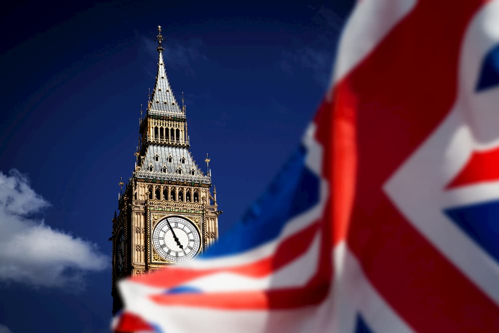 UK flag waves in the area of a Big Ben clock.