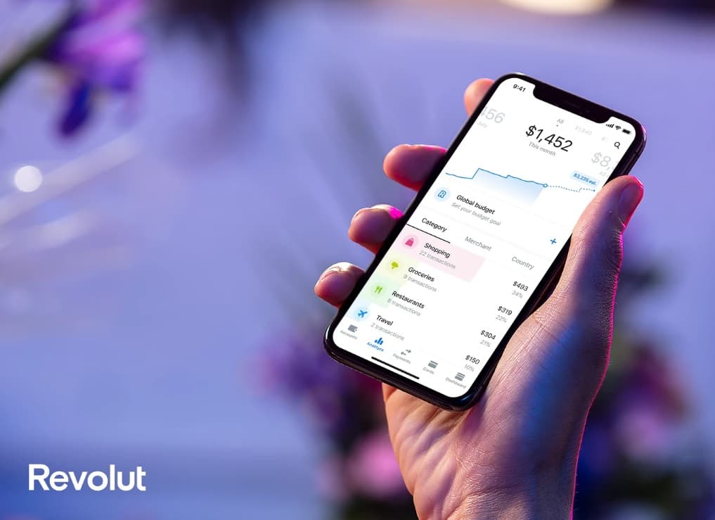 Man hold a smartphone with a opened Revolut app.